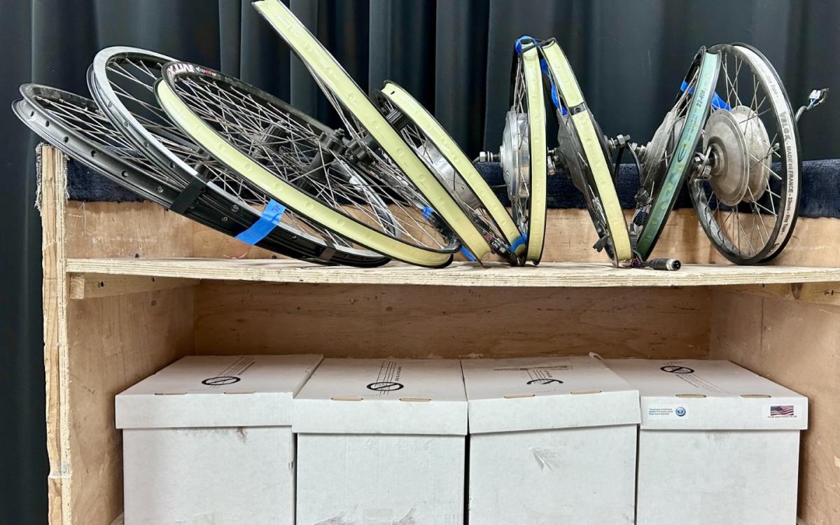 Two shelves full of bicycle parts.