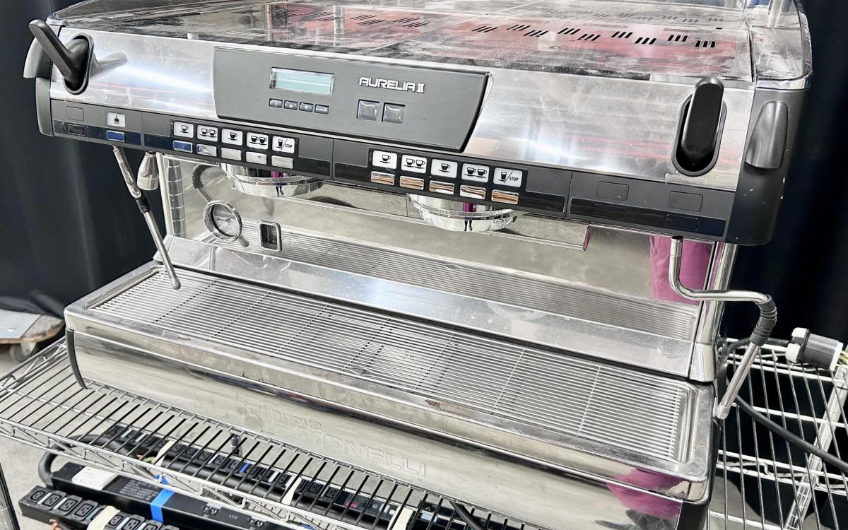 Shiny espresso machine on a cart.