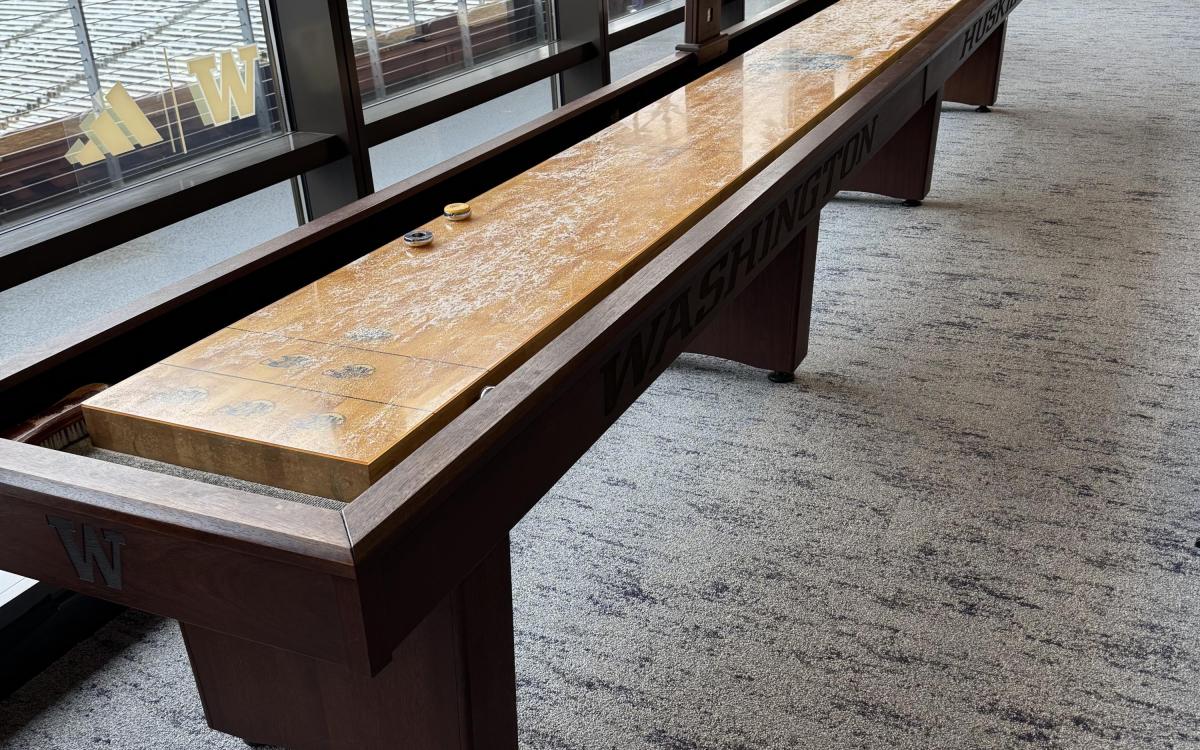 Shuffle board with Husky Stadium seating visible in the background.