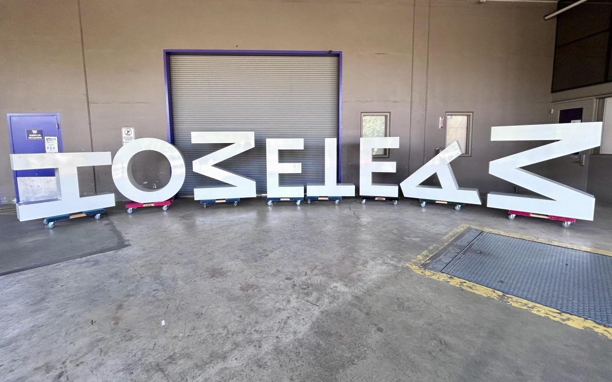 Large letters that spell HOME TEAM on a loading dock. Not all letters are oriented correctly.