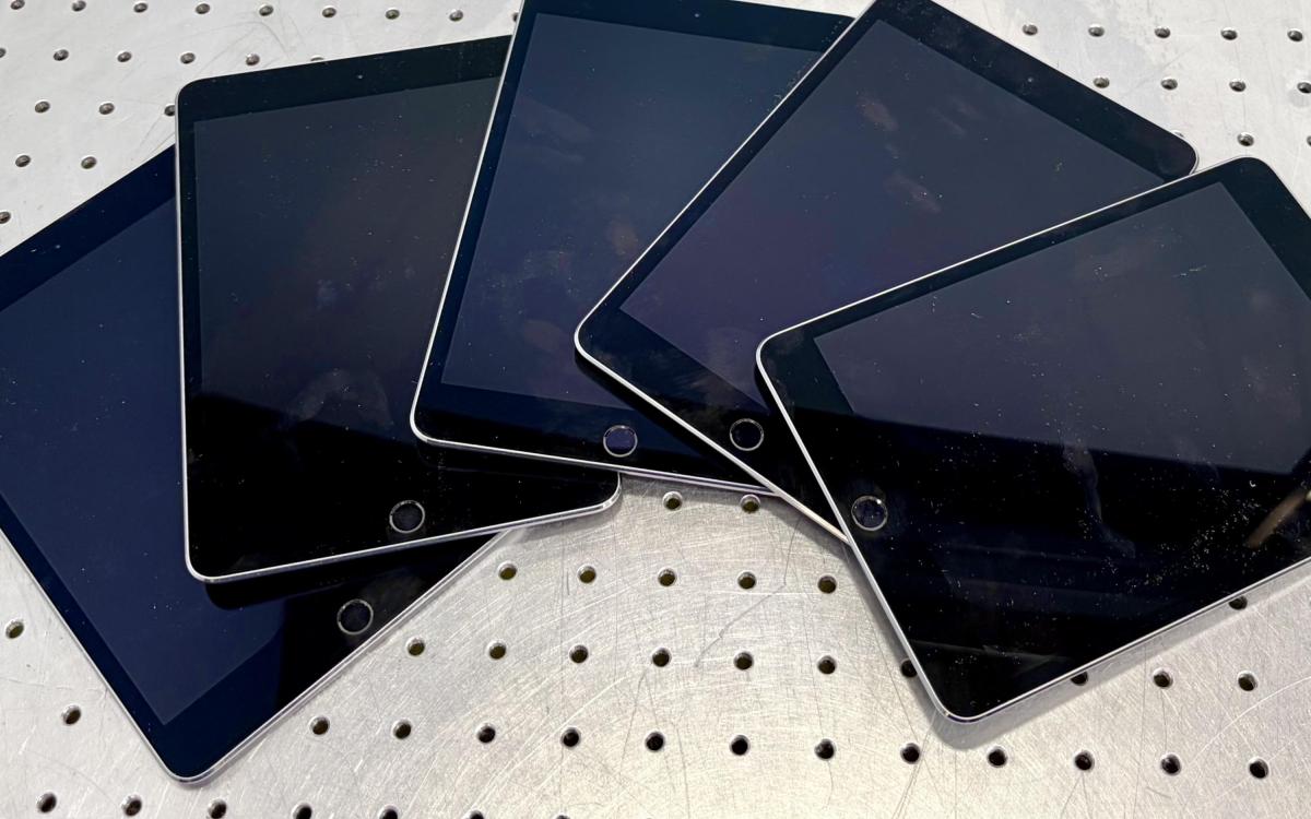 Five iPads fanned out on a table.