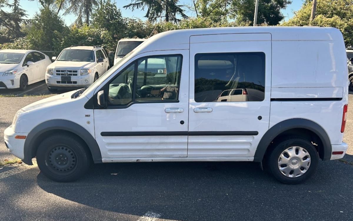 White Ford Transit Connect in parking lot.