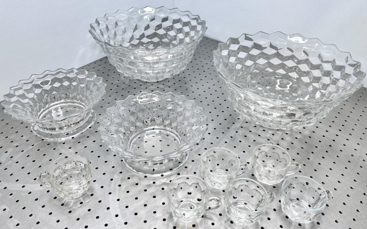 Fancy clear glass bowls and cups on a silver table.