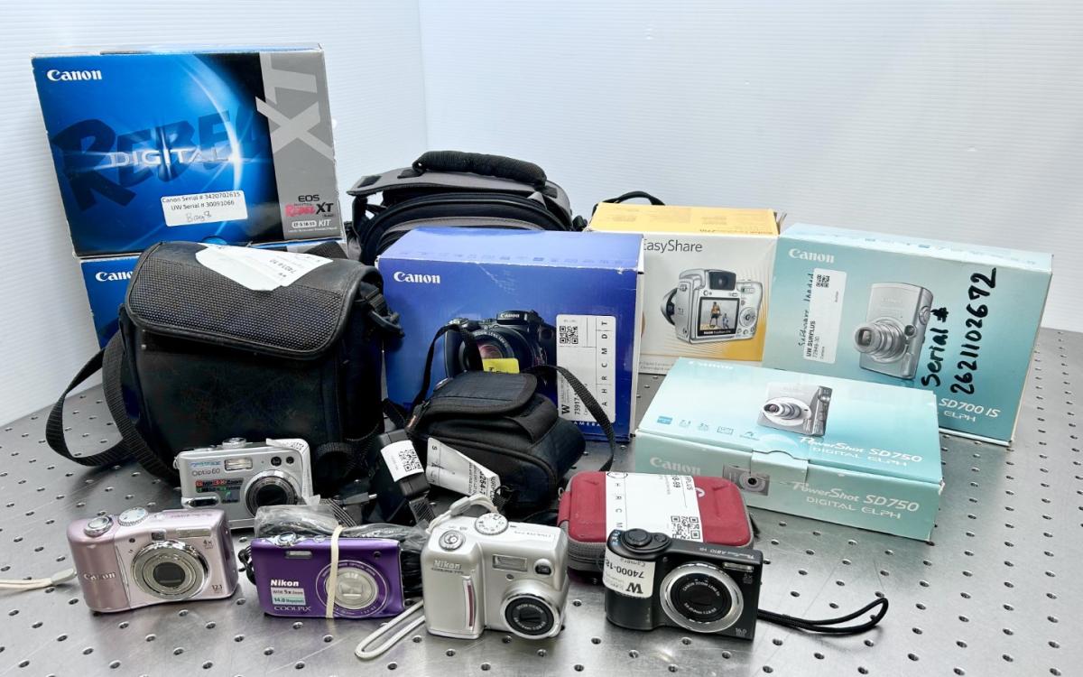 Various digital cameras displayed on a table.