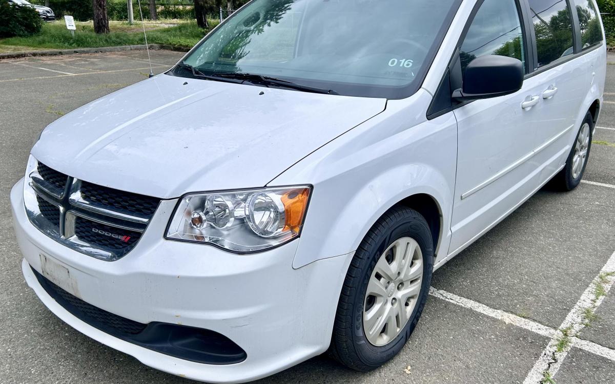 White 2014 Dodge Caravan minivan.