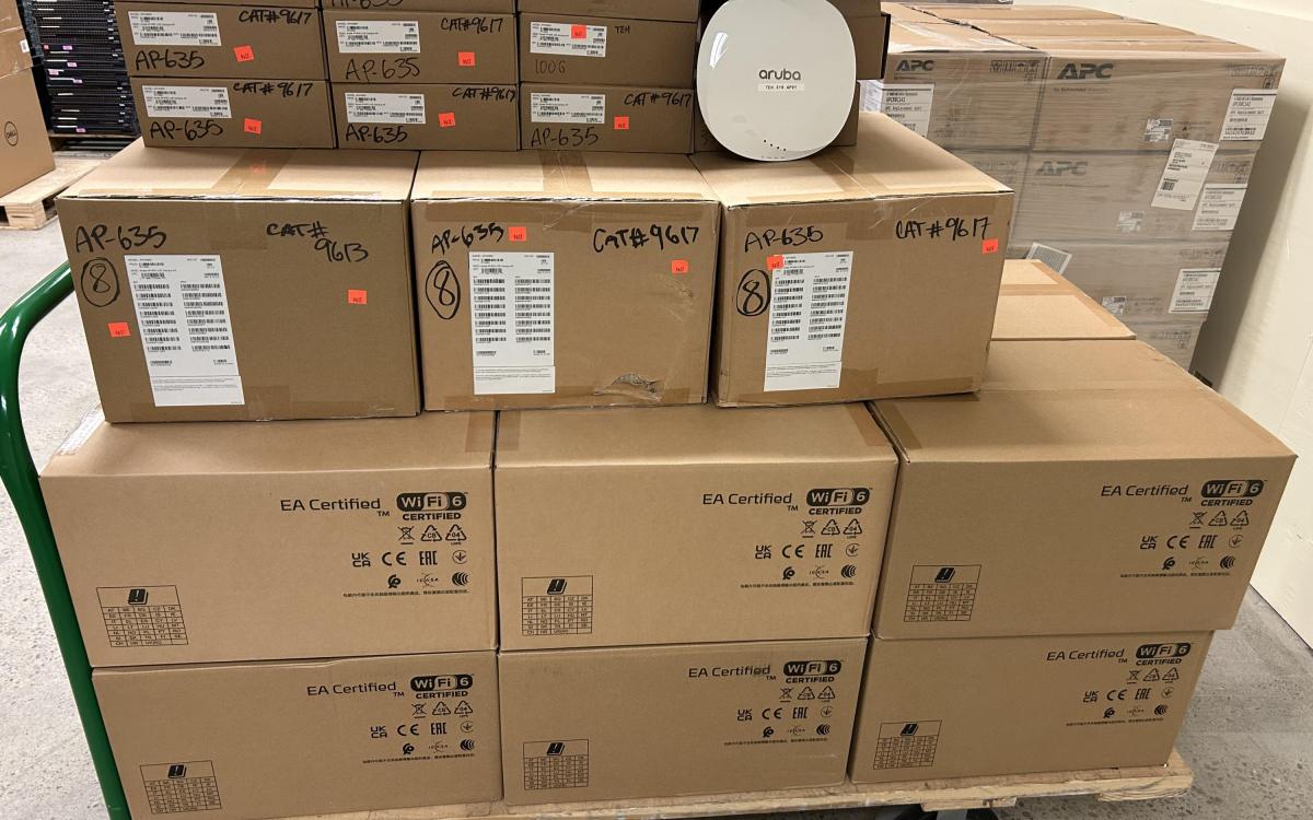 Boxes of Aruba wireless access points on a cart.