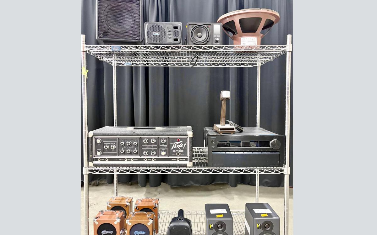 Cart with miscellaneous audio equipment on the shelves.