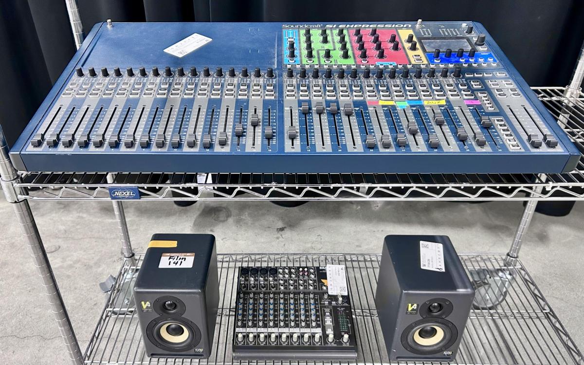 Audio mixers and speakers on a cart.