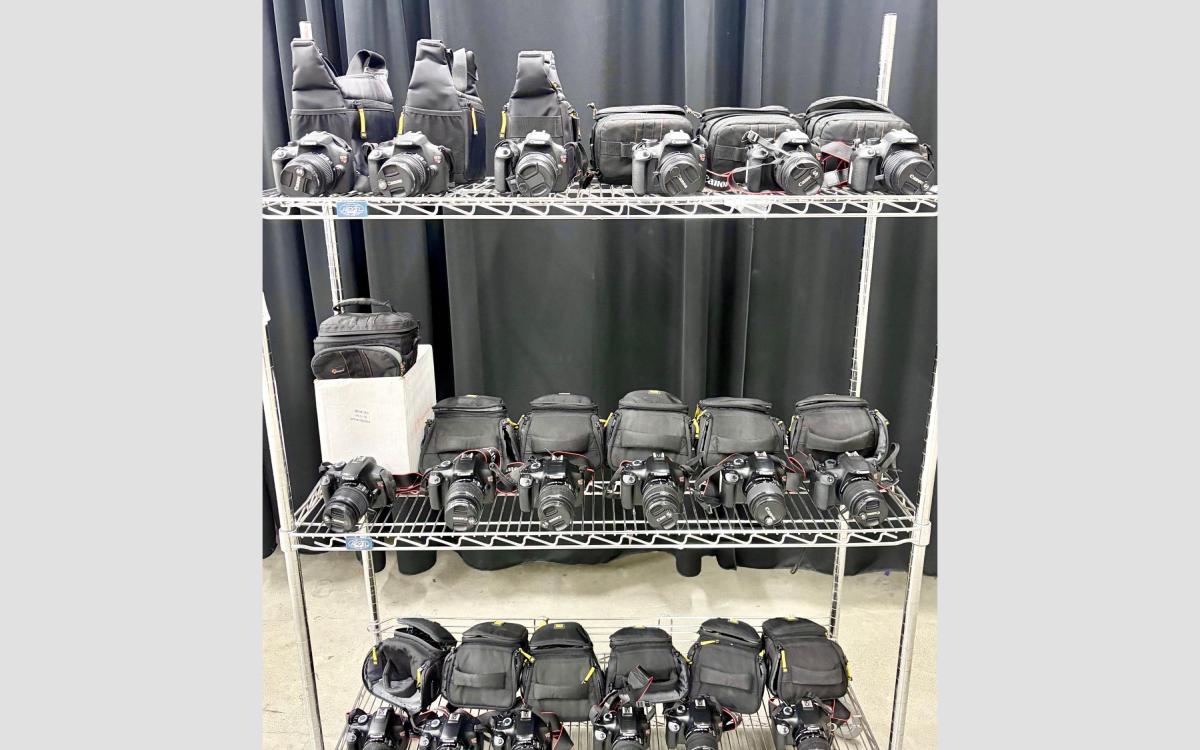 Cart with Canon DSLR cameras on the shelves.