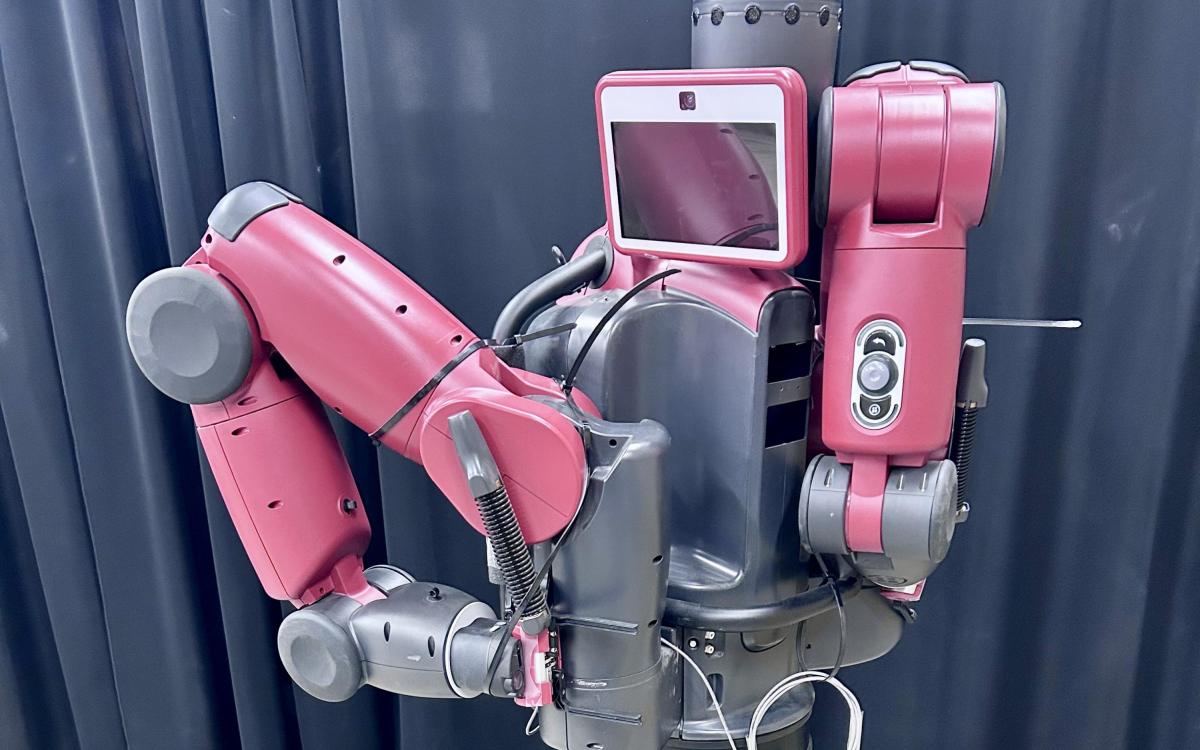 Red industrial robot with two arms and a central screen.