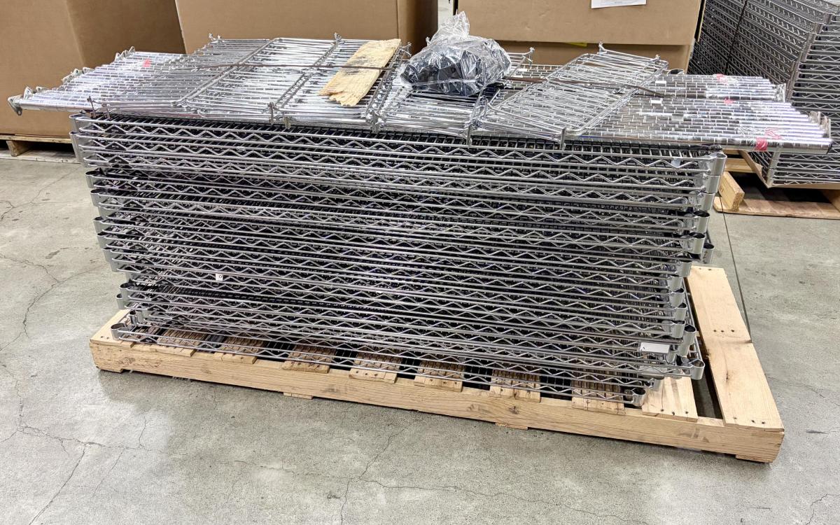 Pallet full of industrial wire shelving pieces.