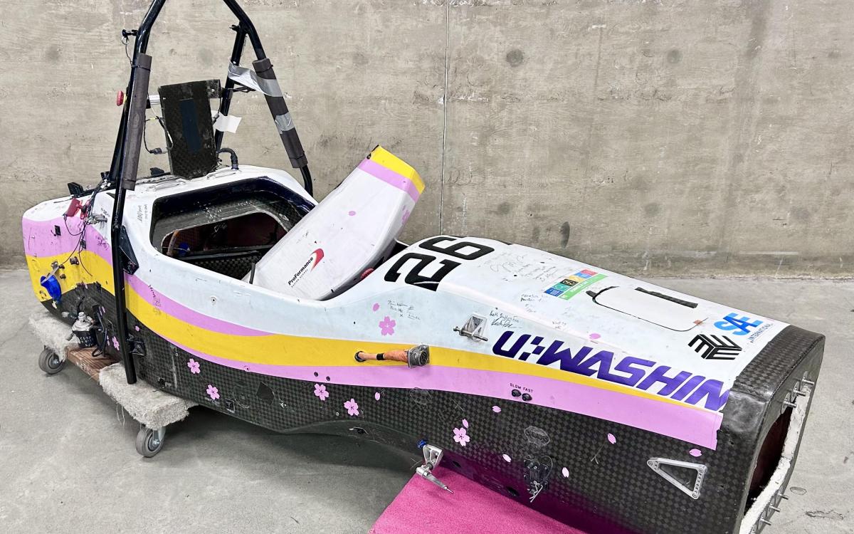 Colorful race car chassis only (no wheels) displayed on carts.