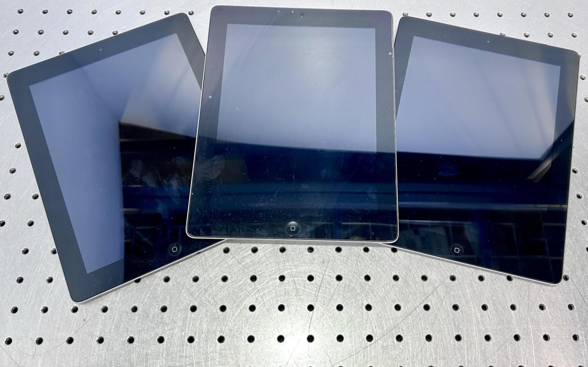 Three iPads on a table.