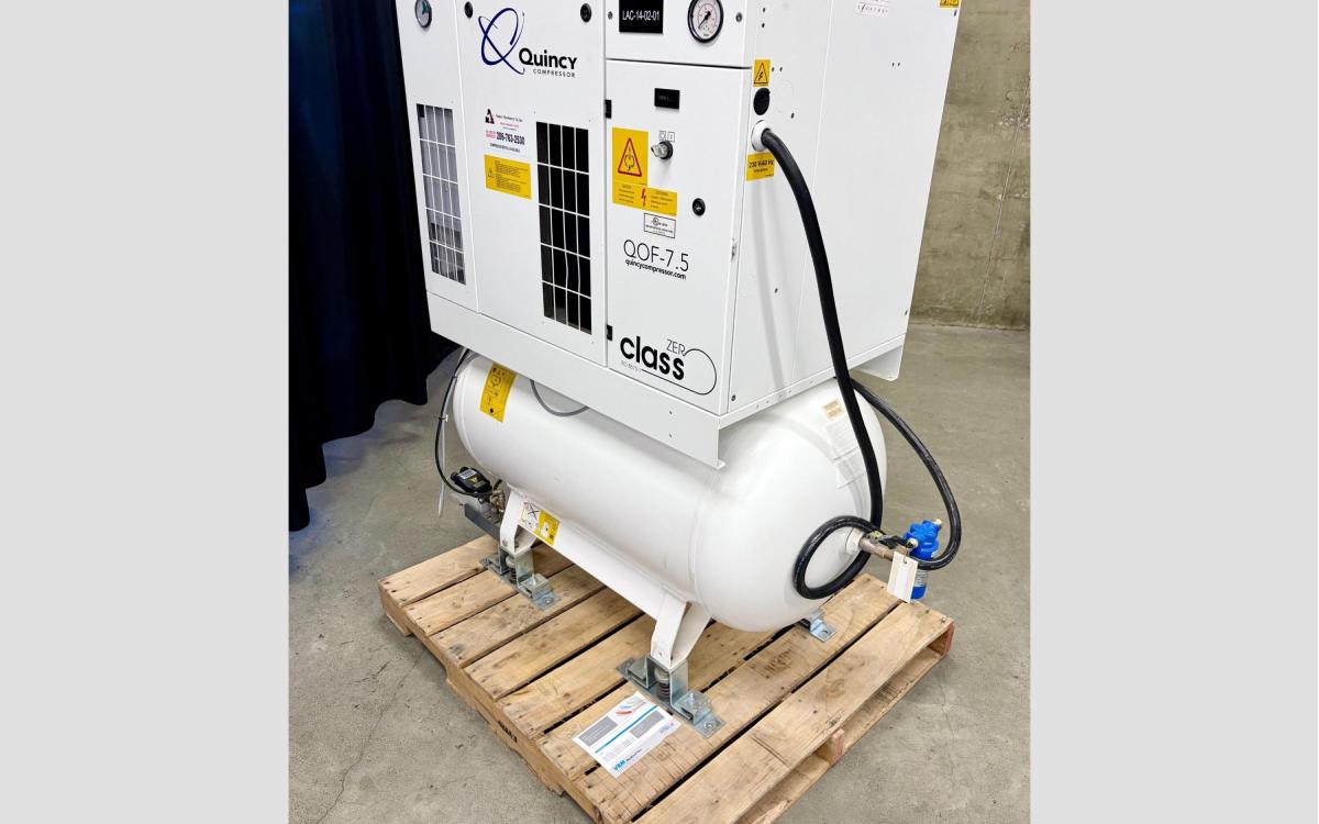 Large white air compressor with an attached tank on a pallet.