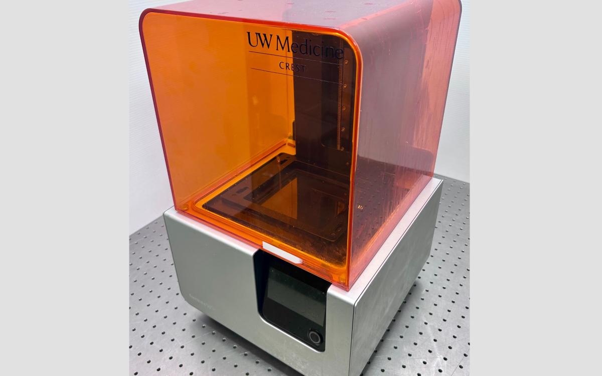 Orange and silver Formlabs 3D printer on a table.