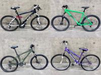 Four bikes: one each of black, lime green, moss green and purple.