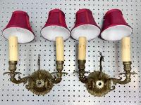 A pair of ornate wall sconces with red shades placed where they would sit on lightbulbs.