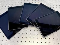 Five iPads fanned out on a table.