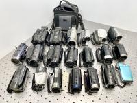 Over 20 camcorders displayed on a table.