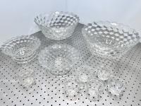 Fancy clear glass bowls and cups on a silver table.