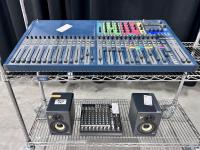 Audio mixers and speakers on a cart.