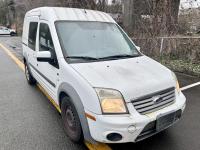 White Ford Transit Connect van in a parking lot.