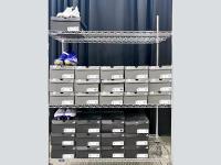 Rack full of 28 pairs of Adidas show boxes with three pairs of cleats visible.
