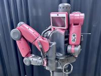 Red industrial robot with two arms and a central screen.