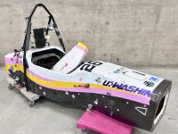 Colorful race car chassis only (no wheels) displayed on carts.