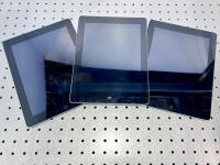 Three iPads on a table.