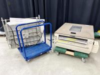 A dry mounting press on a moving cart next to a print dryer.