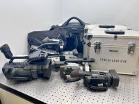 Video cameras, some in cases, on a table.